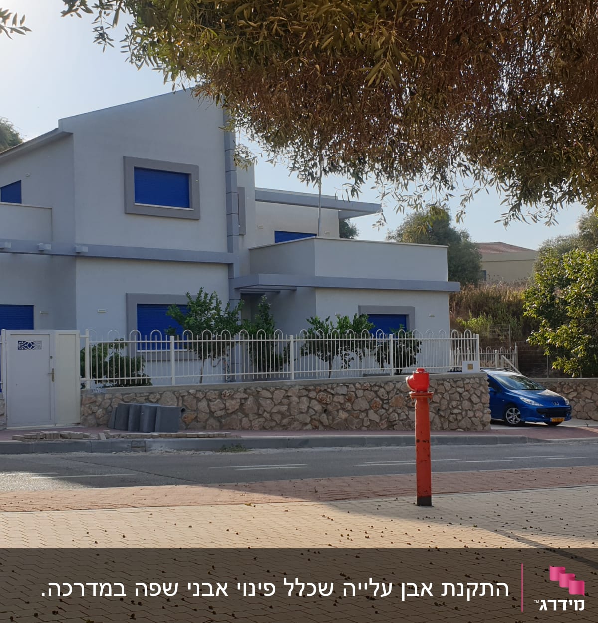 בית עם חלונות כחולים ועצים מסביב